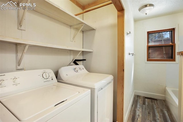 laundry room featuring baseboards, laundry area, wood finished floors, a textured ceiling, and separate washer and dryer