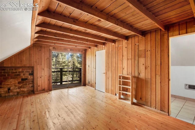 additional living space featuring wooden walls, visible vents, vaulted ceiling with beams, wood ceiling, and hardwood / wood-style flooring