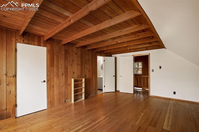 interior space featuring vaulted ceiling with beams, wood ceiling, wood walls, and wood-type flooring