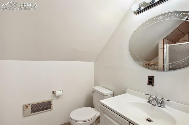 full bathroom with toilet, lofted ceiling, heating unit, an enclosed shower, and vanity