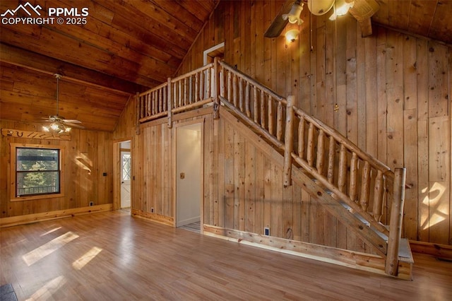 interior space with wood finished floors, ceiling fan, wooden ceiling, and wood walls