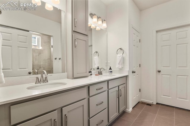 4478 Riviera Ct, Aurora, CO 80019 - full bath with tile patterned flooring, visible vents, a tile shower, and a sink