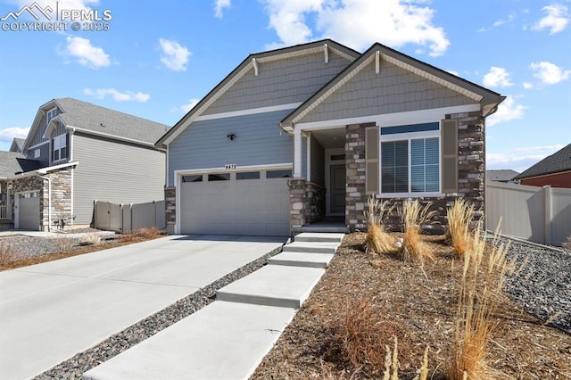 craftsman inspired home featuring concrete driveway, fence, a garage, and stone siding