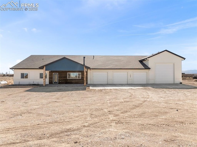 view of front facade with an attached garage and dirt driveway