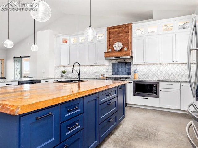 kitchen with lofted ceiling, built in microwave, a sink, wood counters, and a barn door