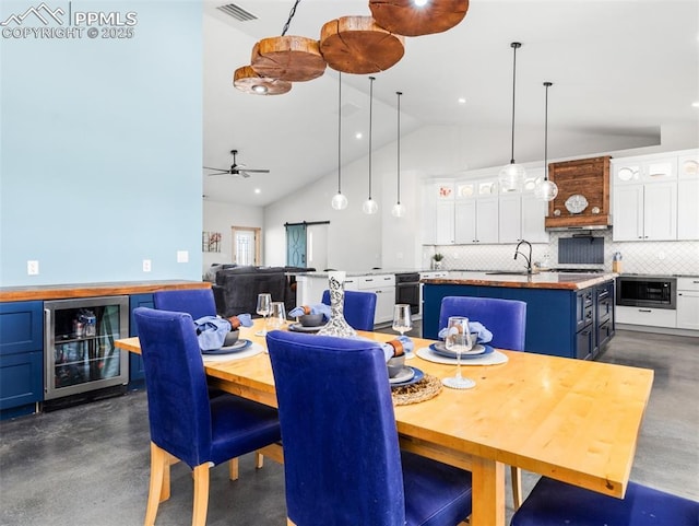 dining room featuring visible vents, wine cooler, finished concrete floors, recessed lighting, and high vaulted ceiling