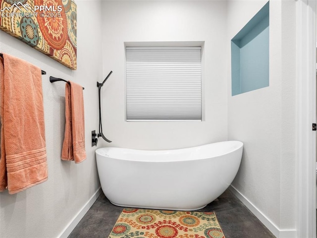 full bath with a soaking tub and baseboards