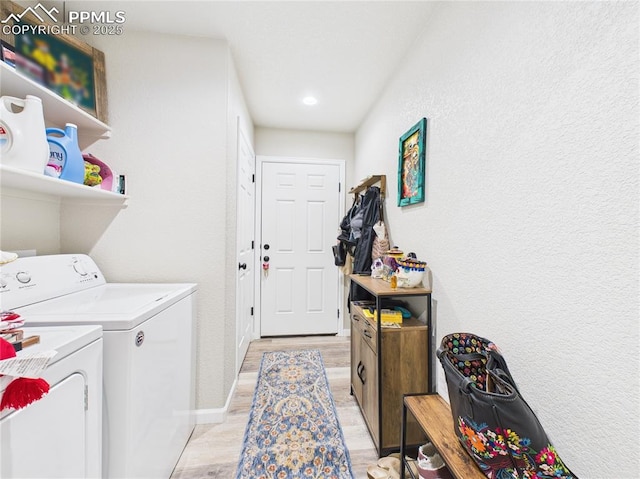 laundry room with laundry area, washer and dryer, baseboards, and light wood-style floors