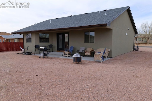 back of house with an outdoor fire pit, a shingled roof, a patio, and fence