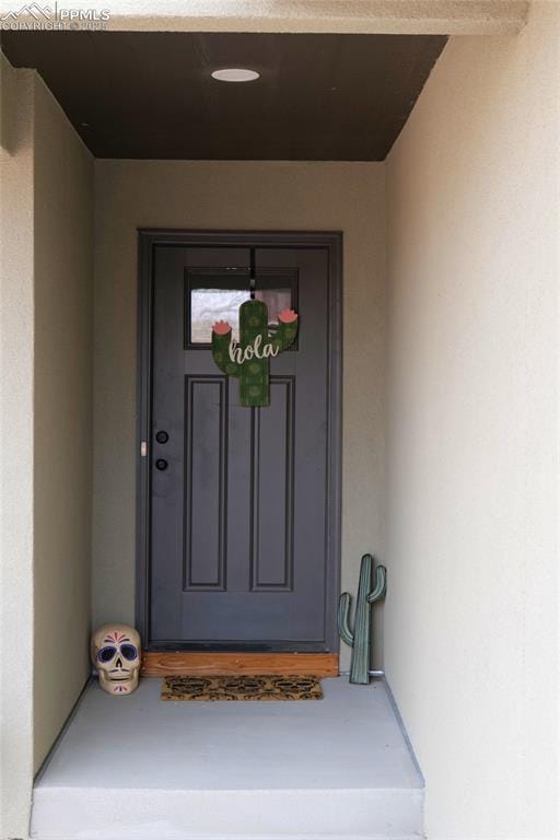 view of exterior entry featuring stucco siding