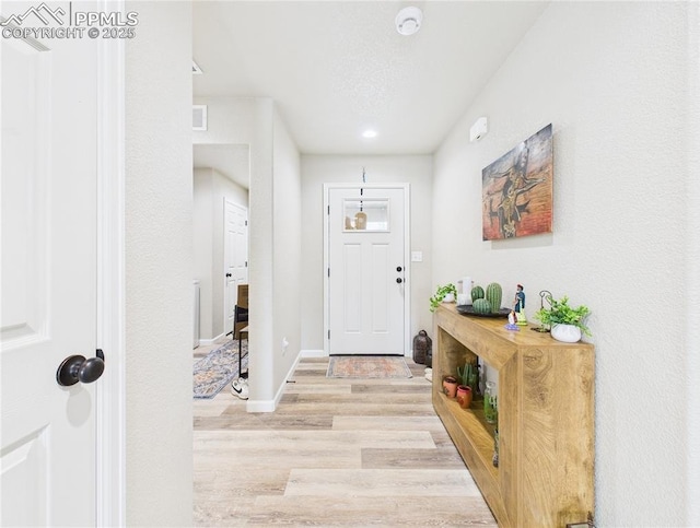 entryway featuring wood finished floors, visible vents, and baseboards