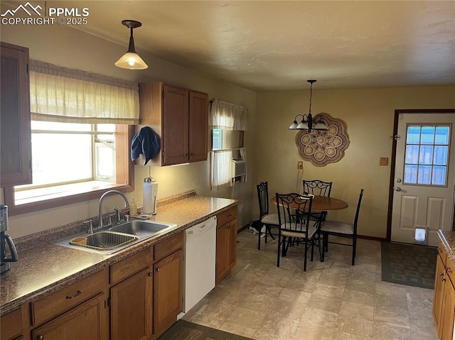 kitchen featuring dishwasher, decorative light fixtures, brown cabinets, and a sink