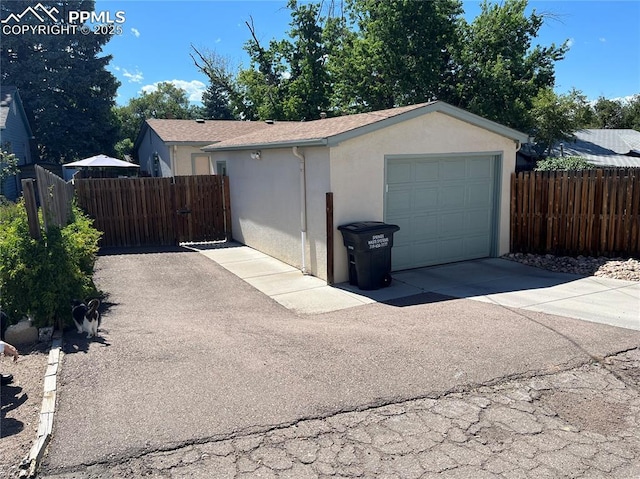 garage featuring fence and driveway