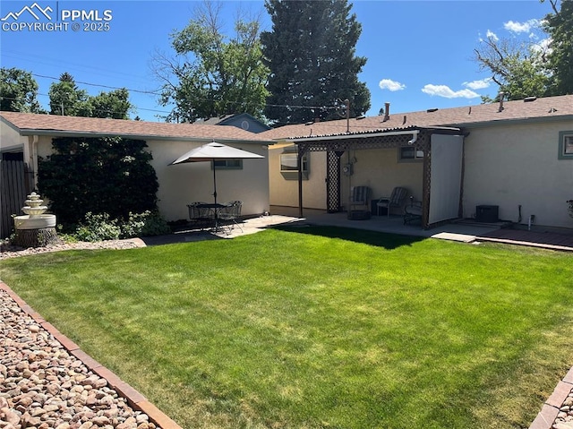 back of property with a patio, a lawn, and stucco siding