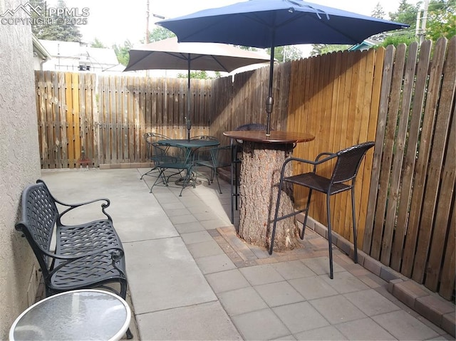 view of patio featuring outdoor dining space and fence