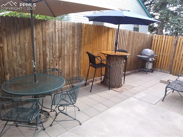 view of patio / terrace featuring grilling area, outdoor dining area, and fence