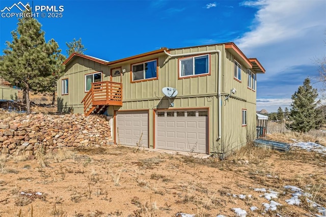 view of front of property with board and batten siding, stairs, and a garage