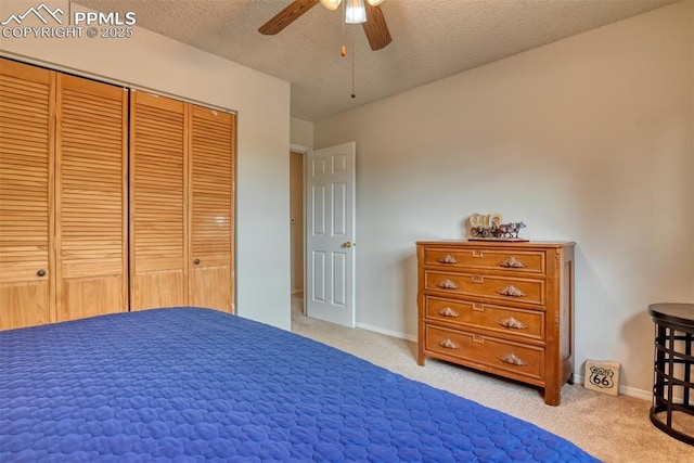 unfurnished bedroom with a closet, carpet flooring, a textured ceiling, baseboards, and a ceiling fan