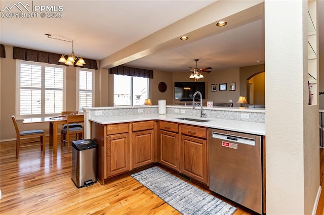 kitchen with dishwasher, light countertops, a wealth of natural light, and a sink