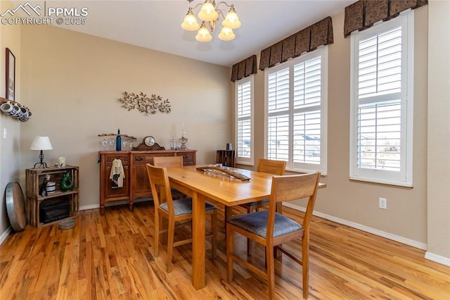 dining area with a chandelier, light wood-type flooring, and baseboards