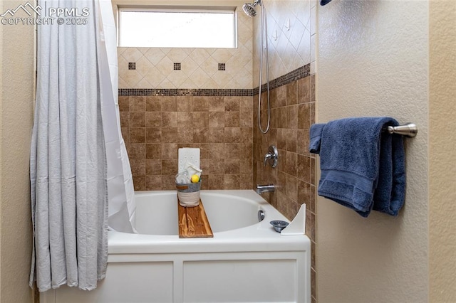 full bathroom with shower / tub combo with curtain and a textured wall