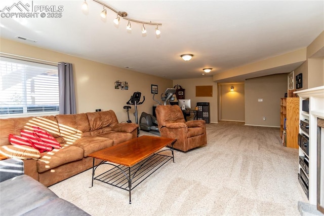 living area featuring visible vents, a fireplace, and carpet floors