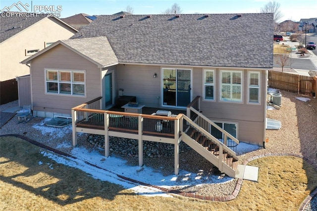 rear view of property featuring a wooden deck, fence, and a shingled roof