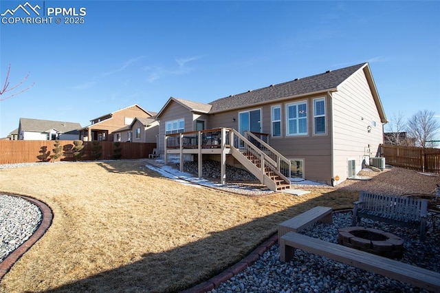 rear view of house featuring stairs, a deck, a fenced backyard, and a fire pit