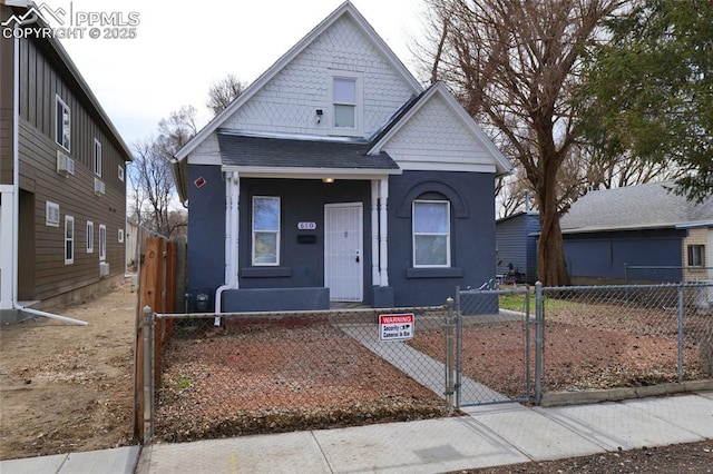 bungalow-style home featuring stucco siding, a gate, a shingled roof, and a fenced front yard
