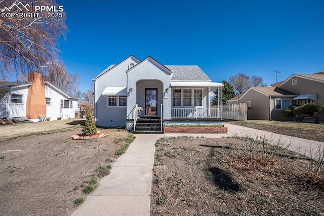 bungalow featuring a porch and stucco siding