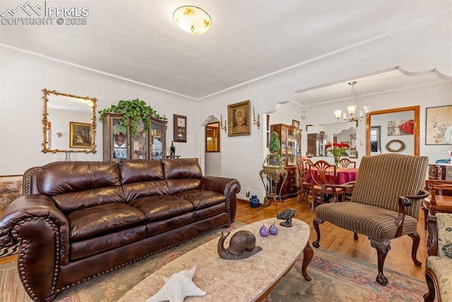 living area featuring wood finished floors, arched walkways, and a chandelier