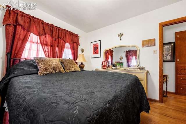 bedroom with baseboards and wood finished floors