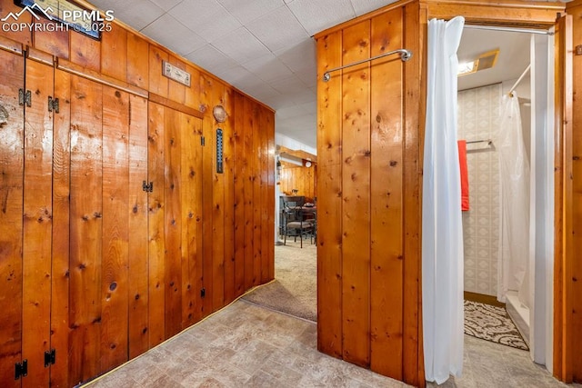 hallway with wooden walls and carpet floors