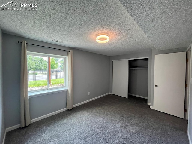 4535 Lamplighter Cir, Colorado Springs, CO 80916 - unfurnished bedroom with a closet, a textured ceiling, baseboards, visible vents, and dark carpet