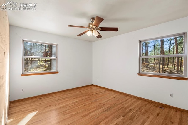 empty room with visible vents, baseboards, and light wood finished floors