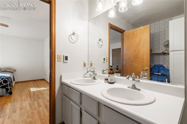 bathroom featuring double vanity, wood finished floors, and a sink