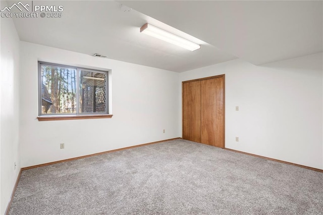 carpeted empty room with visible vents and baseboards