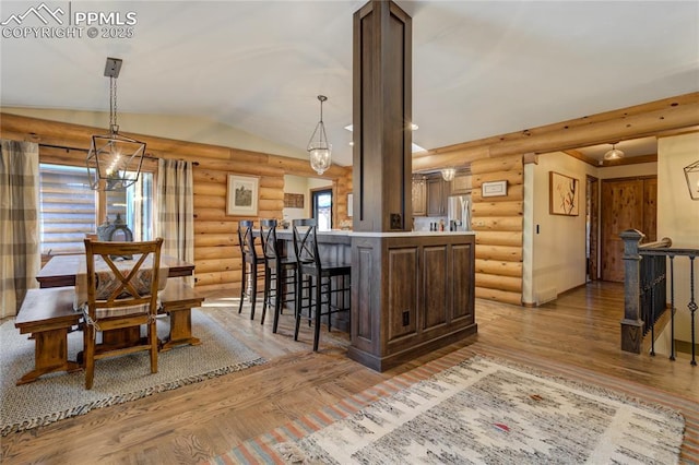 kitchen featuring a kitchen bar, lofted ceiling, light countertops, and light wood finished floors