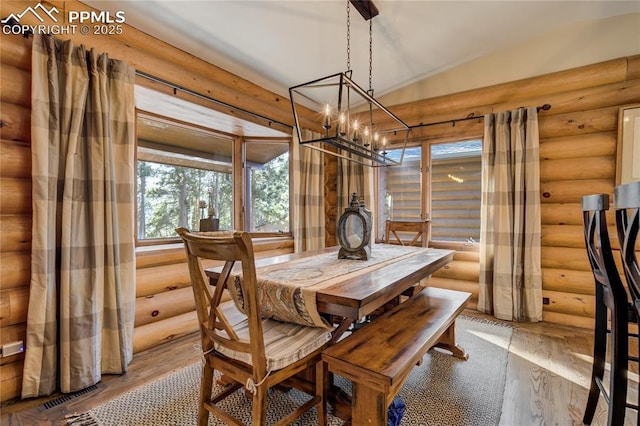 dining area with visible vents, log walls, an inviting chandelier, and wood finished floors