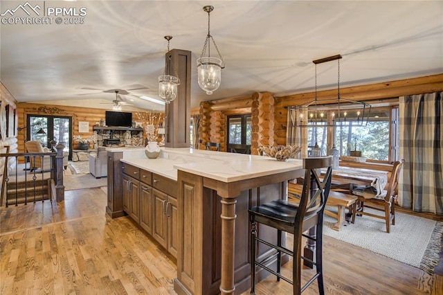 kitchen featuring rustic walls, open floor plan, light wood-type flooring, and vaulted ceiling