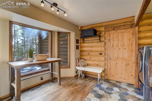 interior space featuring visible vents, washer / clothes dryer, light wood-style floors, and baseboards