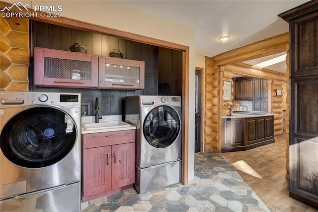 laundry area featuring a sink, cabinet space, and washing machine and clothes dryer