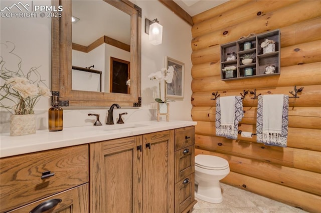 bathroom featuring log walls, toilet, and vanity