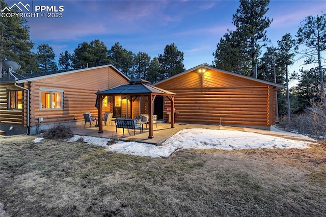 view of front of house featuring a gazebo, log exterior, and a patio area