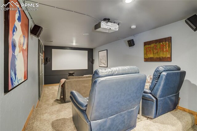 home theater room featuring light colored carpet and baseboards