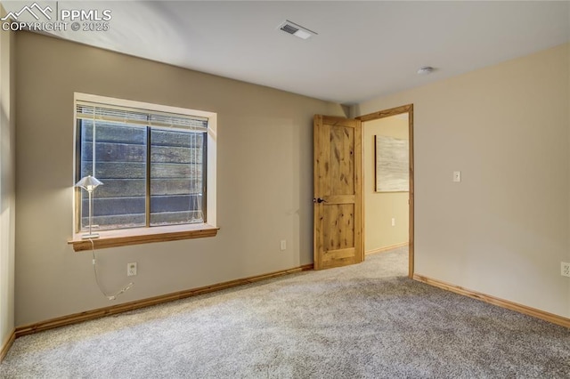 carpeted empty room with visible vents and baseboards