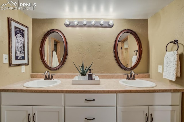 full bathroom with a sink, double vanity, and a textured wall