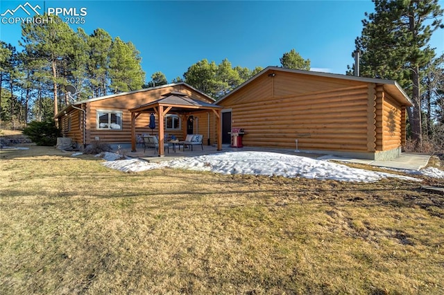 log-style house featuring a patio, log exterior, and a front lawn