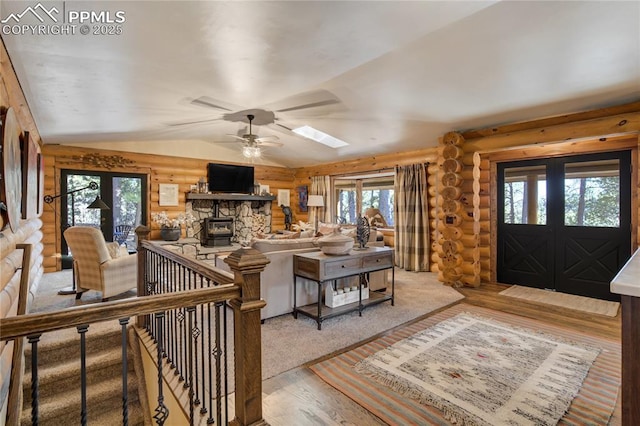 living room with ceiling fan, lofted ceiling, french doors, wood finished floors, and log walls