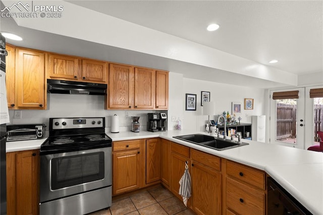 kitchen featuring under cabinet range hood, stainless steel electric range oven, light countertops, and a sink